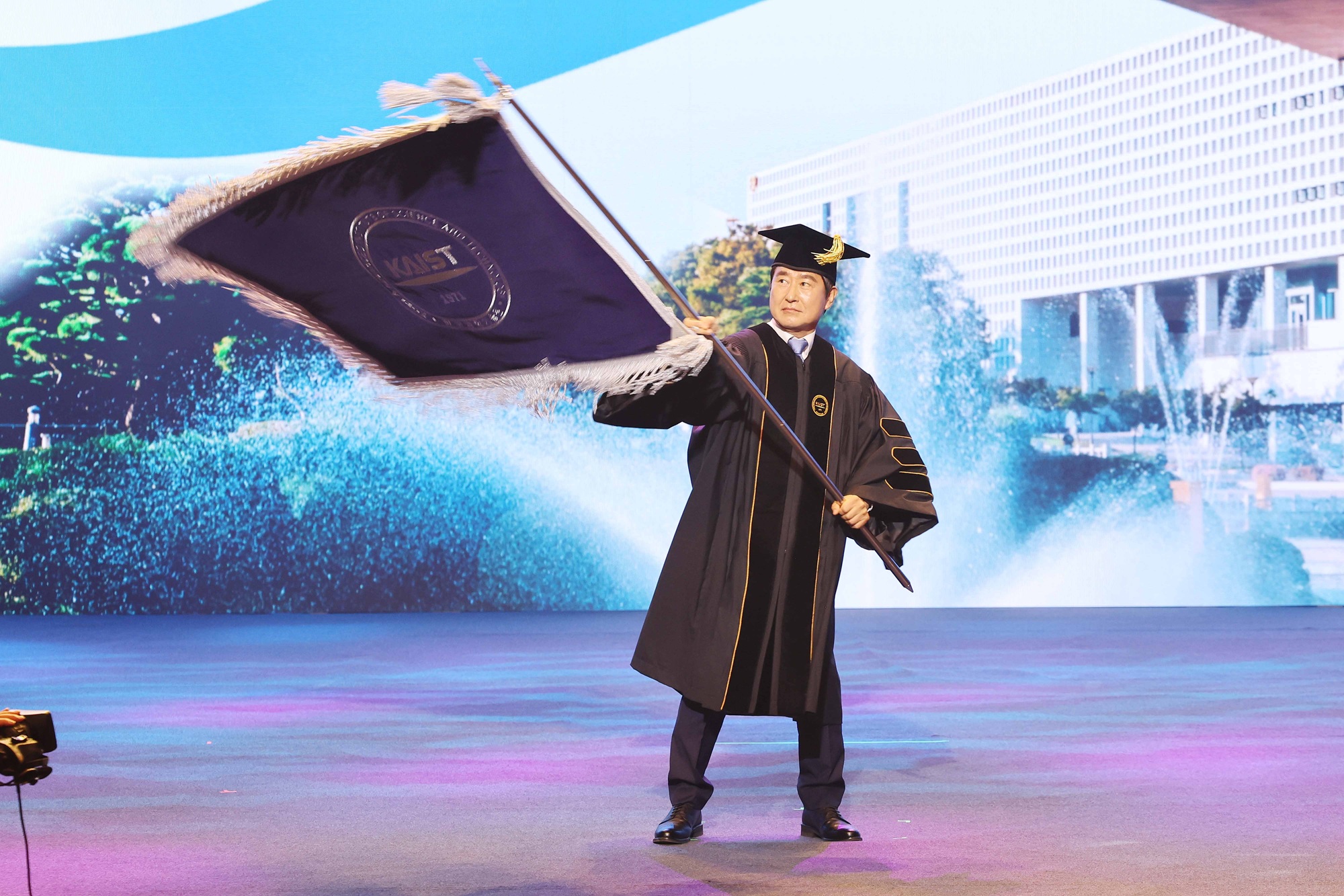 President Choongsik Bae waving the university flag President Choongsik Bae waving the university flag